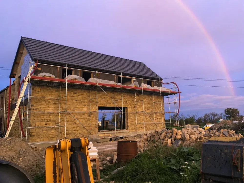 Rénovation de façade en pierre avec toiture et échafaudage